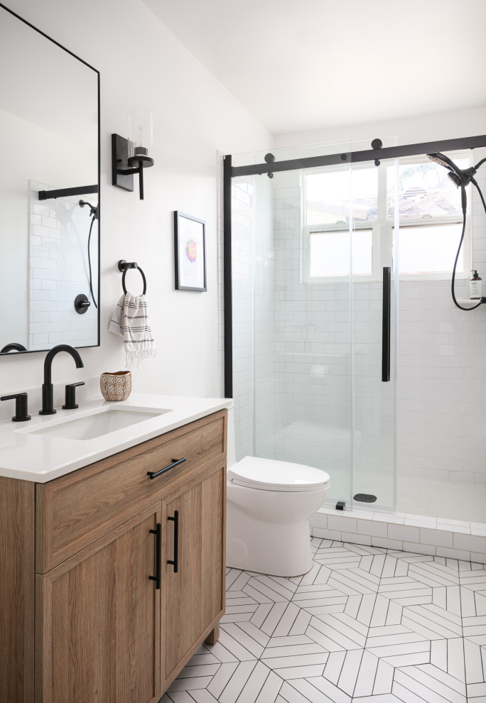 Small traditional shower room bathroom in Los Angeles with shaker cabinets, medium wood cabinets, an alcove shower, a two-piece toilet, white tiles, metro tiles, white walls, concrete flooring, a submerged sink, engineered stone worktops, white floors, a sliding door, white worktops, a single sink and a freestanding vanity unit.