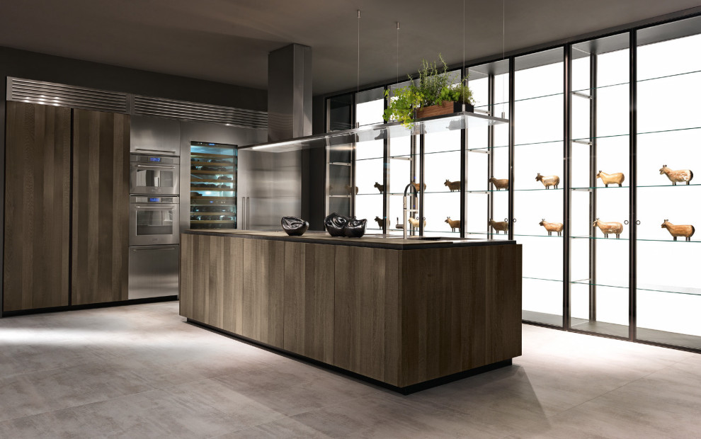 Idee per una grande cucina moderna con lavello a tripla vasca, ante di vetro, ante in legno scuro, top in legno, pavimento in cemento e top marrone