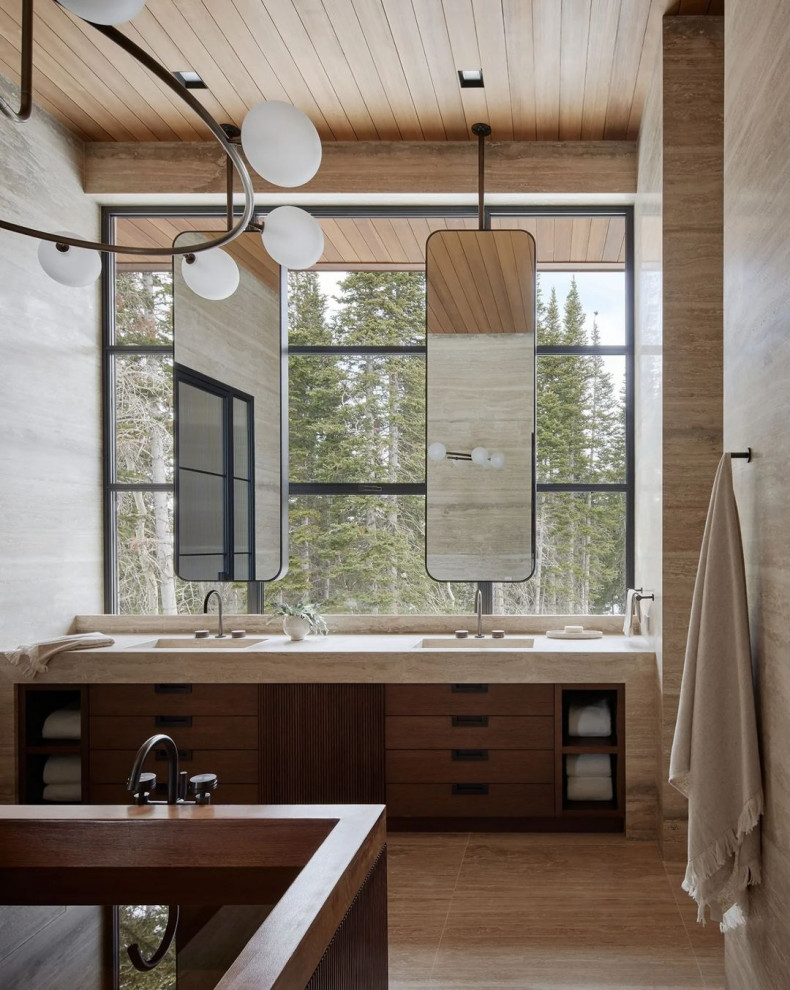 Large modern master bathroom in Salt Lake City with flat-panel cabinets, beige tile, beige walls, an integrated sink, beige floor, a hinged shower door, an enclosed toilet, a double vanity, a floating vanity, a freestanding tub, a corner shower, travertine, travertine floors, solid surface benchtops, beige benchtops and wood.