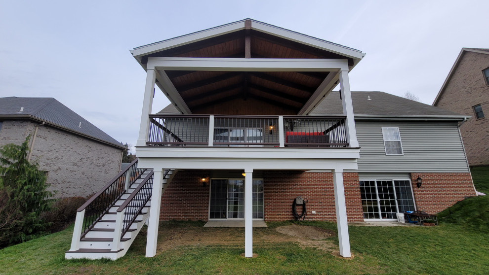 Inspiration for a mid-sized backyard second story metal railing deck remodel with a roof extension