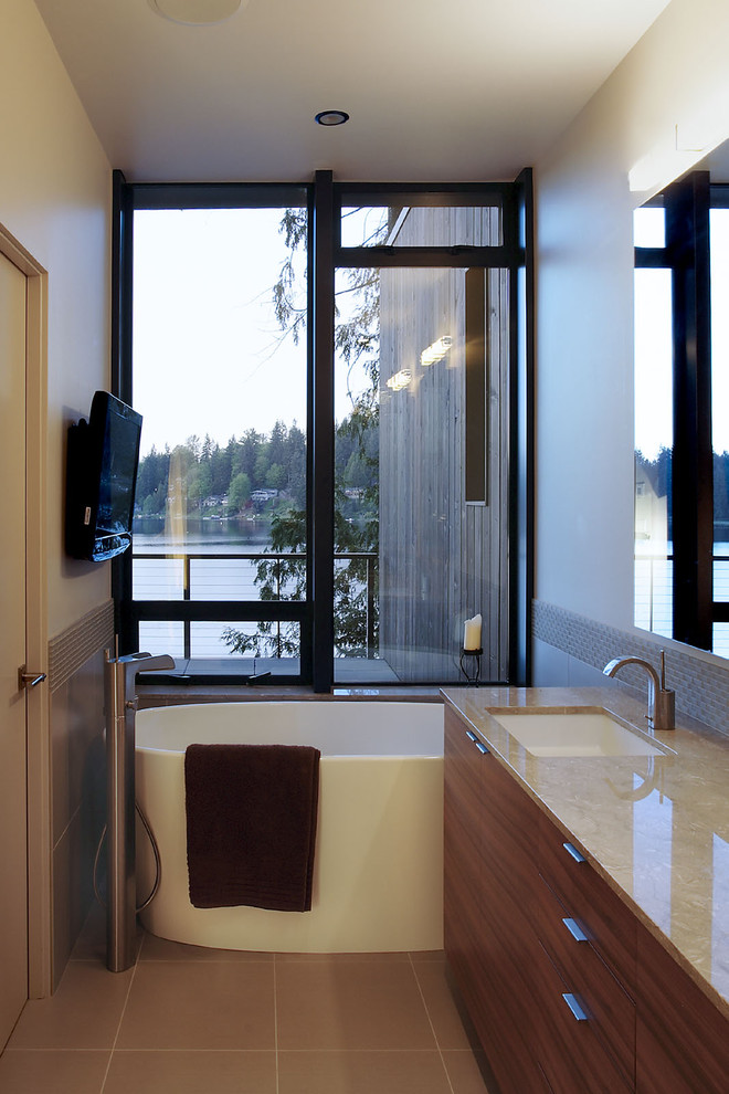 Modern bathroom in Seattle with an undermount sink, flat-panel cabinets, dark wood cabinets and a freestanding tub.