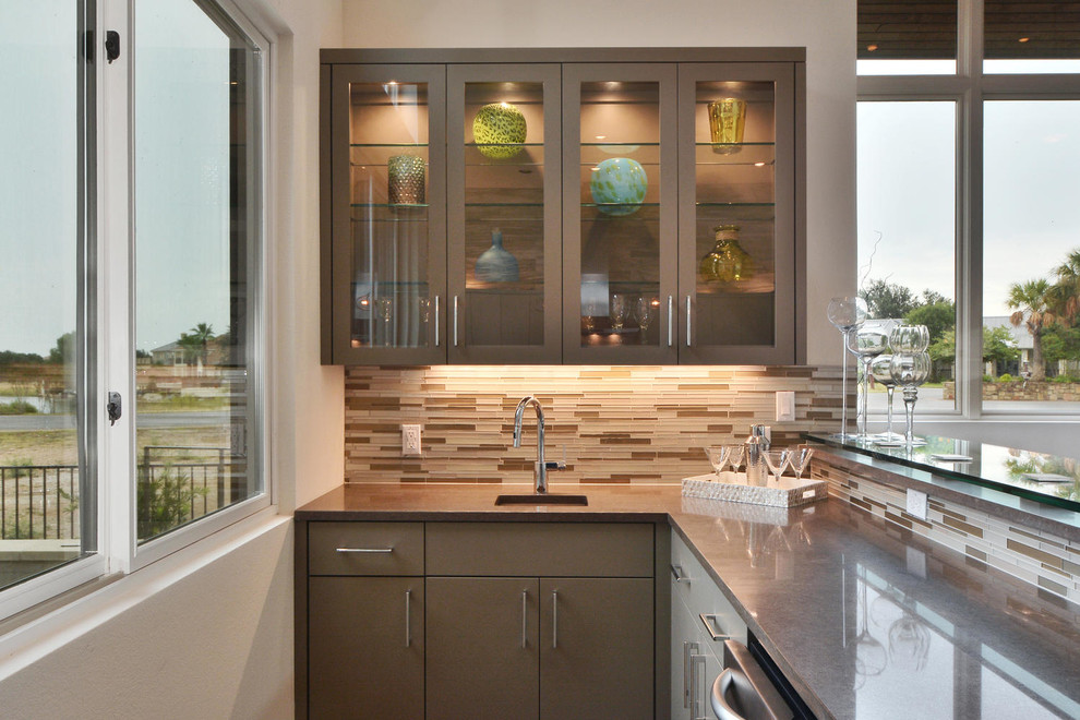 This is an example of a large contemporary l-shaped wet bar in Austin with an undermount sink, glass-front cabinets, brown cabinets, quartz benchtops, multi-coloured splashback, glass tile splashback and concrete floors.