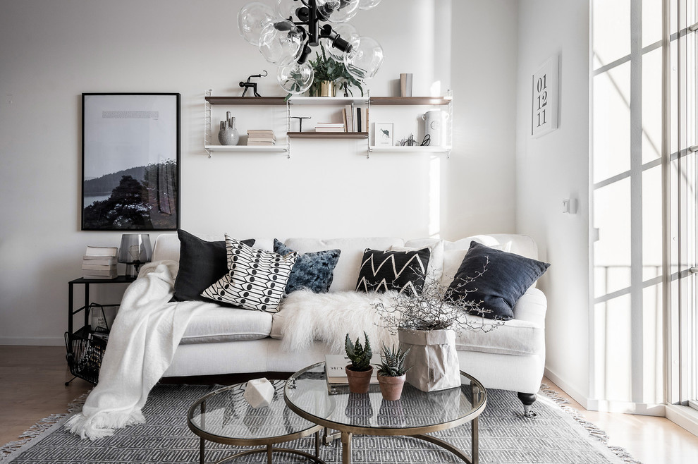 This is an example of a mid-sized scandinavian formal living room in Gothenburg with white walls, light hardwood floors and no tv.
