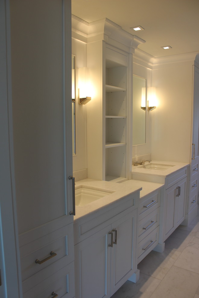 Inspiration for a large transitional master marble floor and white floor doorless shower remodel with shaker cabinets, white cabinets, marble countertops, white countertops, white walls and an undermount sink