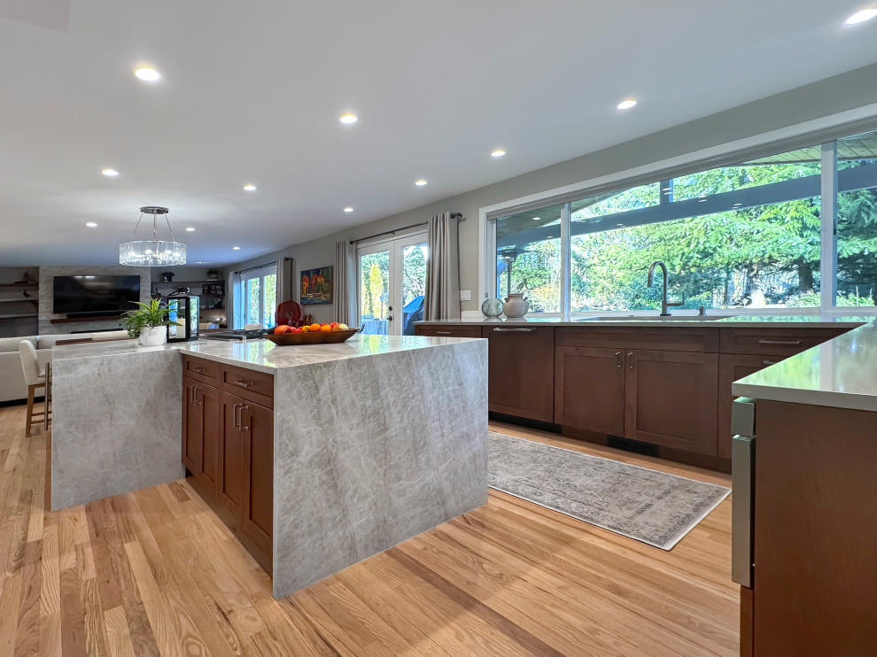 Inspiration for a large transitional u-shaped light wood floor and beige floor eat-in kitchen remodel in Seattle with a single-bowl sink, shaker cabinets, medium tone wood cabinets, quartzite countertops, white backsplash, ceramic backsplash, stainless steel appliances, an island and beige countertops