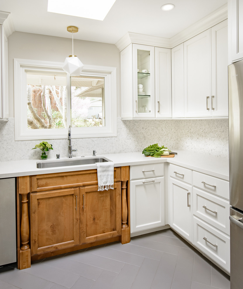Mid-sized traditional l-shaped eat-in kitchen in San Francisco with an undermount sink, white cabinets, mosaic tile splashback, no island, shaker cabinets, white splashback and stainless steel appliances.