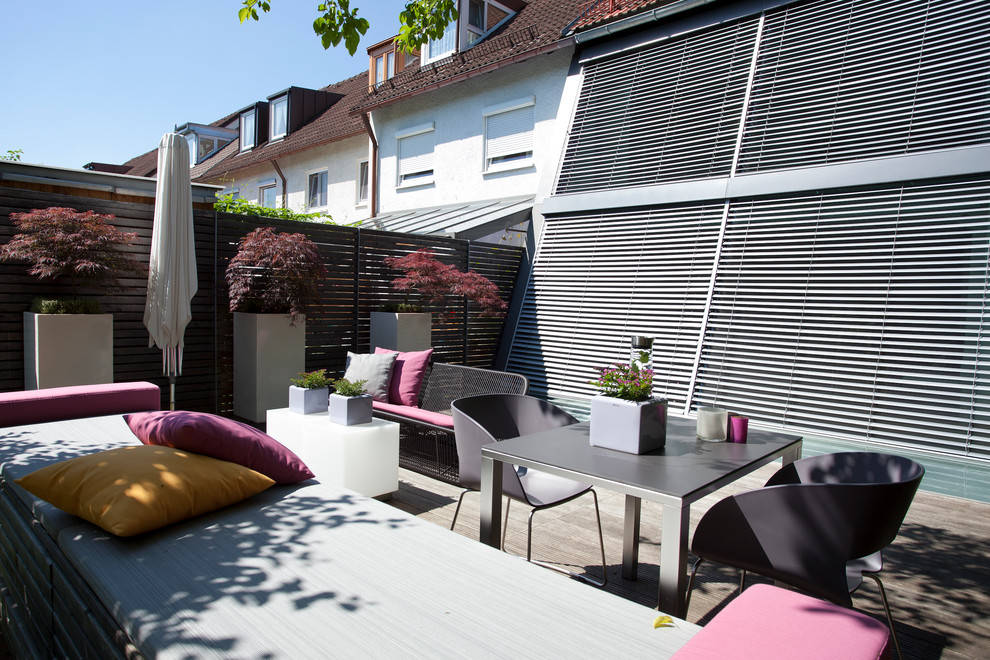This is an example of a mid-sized contemporary side yard deck in Munich with a container garden and no cover.