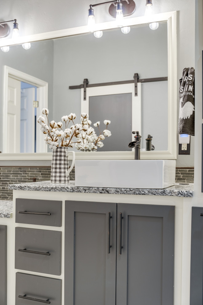 Inspiration for a large country master bathroom in Oklahoma City with shaker cabinets, a curbless shower, white tile, porcelain tile, blue walls, porcelain floors, a vessel sink, granite benchtops, grey floor, an open shower, grey benchtops, a double vanity and a built-in vanity.