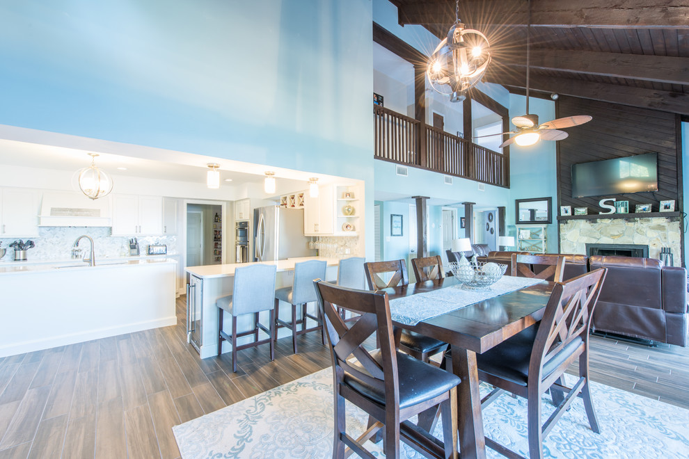 Example of a large transitional u-shaped porcelain tile and brown floor eat-in kitchen design with an undermount sink, shaker cabinets, white cabinets, quartz countertops, white backsplash, marble backsplash, stainless steel appliances and two islands