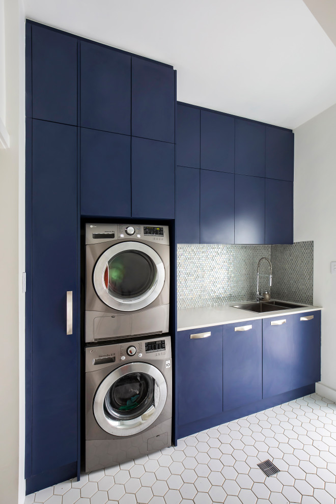 This is an example of a medium sized contemporary single-wall separated utility room in Sydney with a double-bowl sink, flat-panel cabinets, blue cabinets, engineered stone countertops, multi-coloured splashback, mosaic tiled splashback, white walls, porcelain flooring, a stacked washer and dryer, white floors, white worktops, a vaulted ceiling and tongue and groove walls.