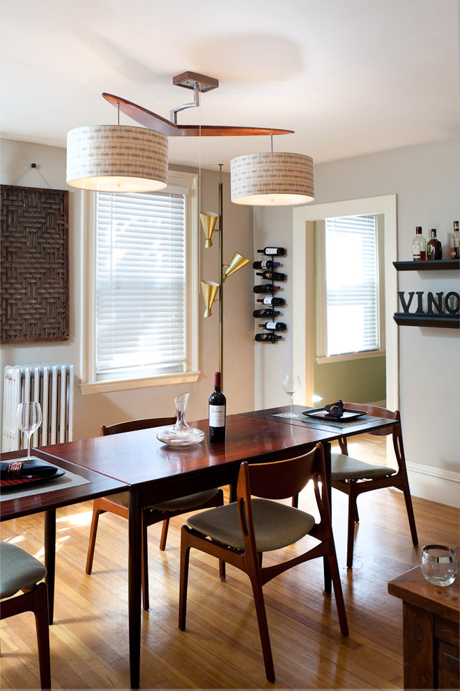 Photo of a midcentury dining room in Portland Maine with grey walls and medium hardwood floors.