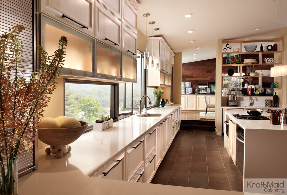 Photo of a contemporary l-shaped eat-in kitchen in Detroit with recessed-panel cabinets, light wood cabinets and stainless steel appliances.