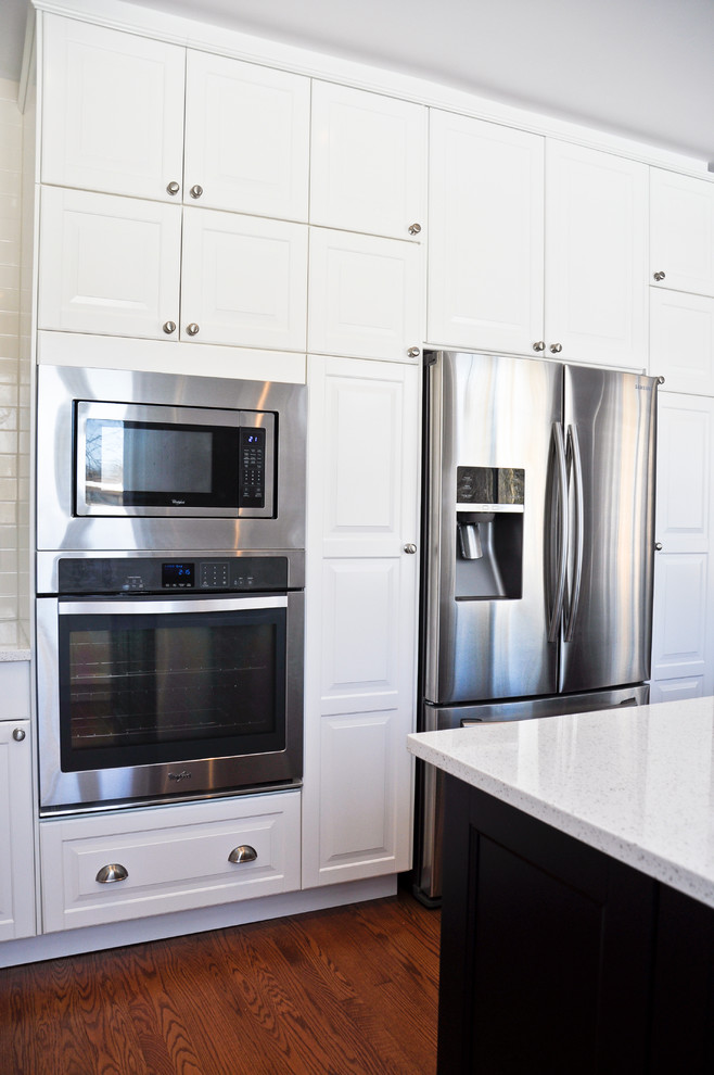 Inspiration for a transitional eat-in kitchen remodel in Ottawa with an undermount sink, raised-panel cabinets, white cabinets, quartz countertops, white backsplash, porcelain backsplash, stainless steel appliances and an island