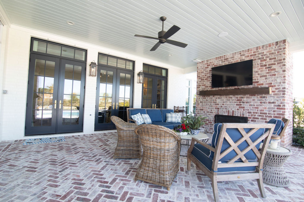 Foto di un grande patio o portico tradizionale dietro casa con un caminetto, pavimentazioni in mattoni e un tetto a sbalzo