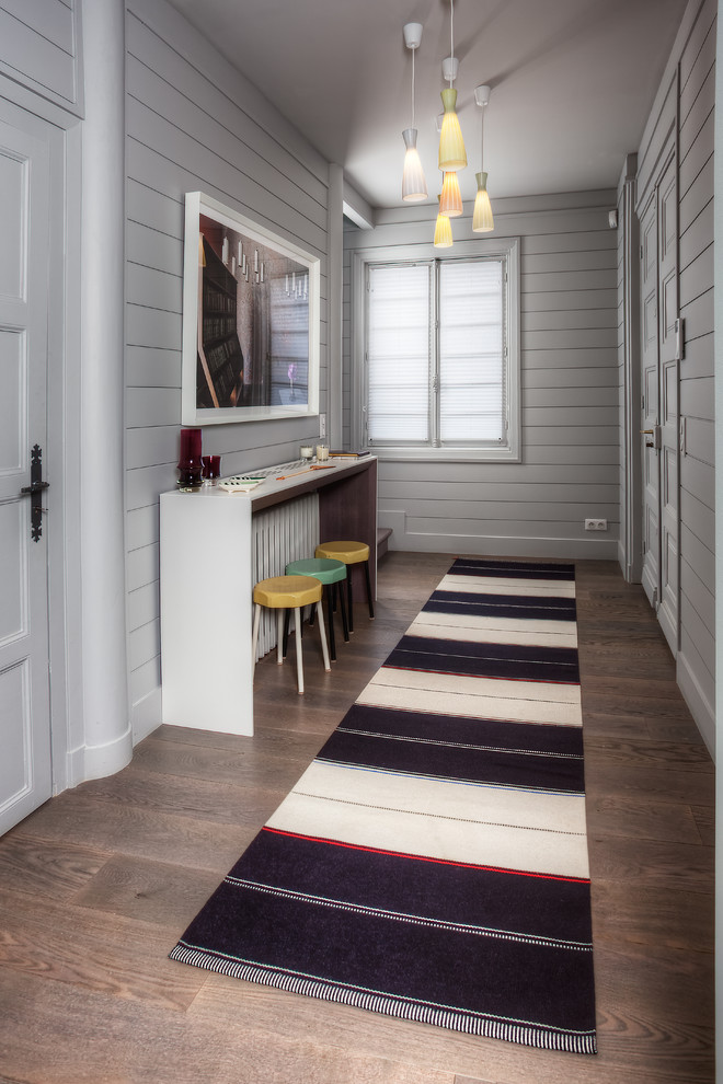 Aménagement d'un grand couloir bord de mer avec un mur gris et un sol en bois brun.