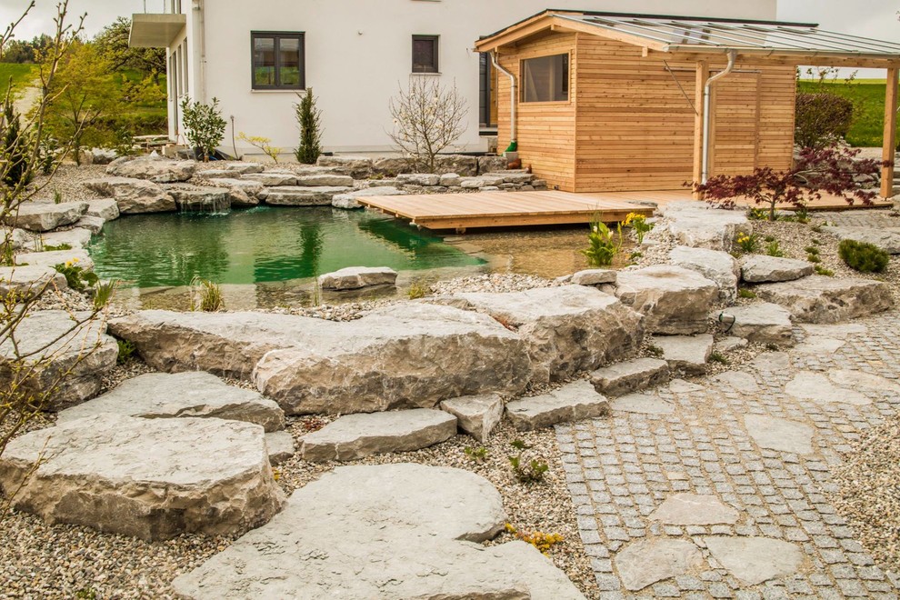 Gartenteich im Innenhof mit direkter Sonneneinstrahlung, Natursteinplatten und Teich in Munich