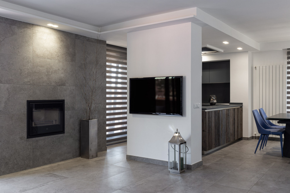 Источник вдохновения для домашнего уюта: большая гостиная-столовая в стиле лофт с серыми стенами, полом из керамогранита, горизонтальным камином, фасадом камина из плитки, серым полом и многоуровневым потолком