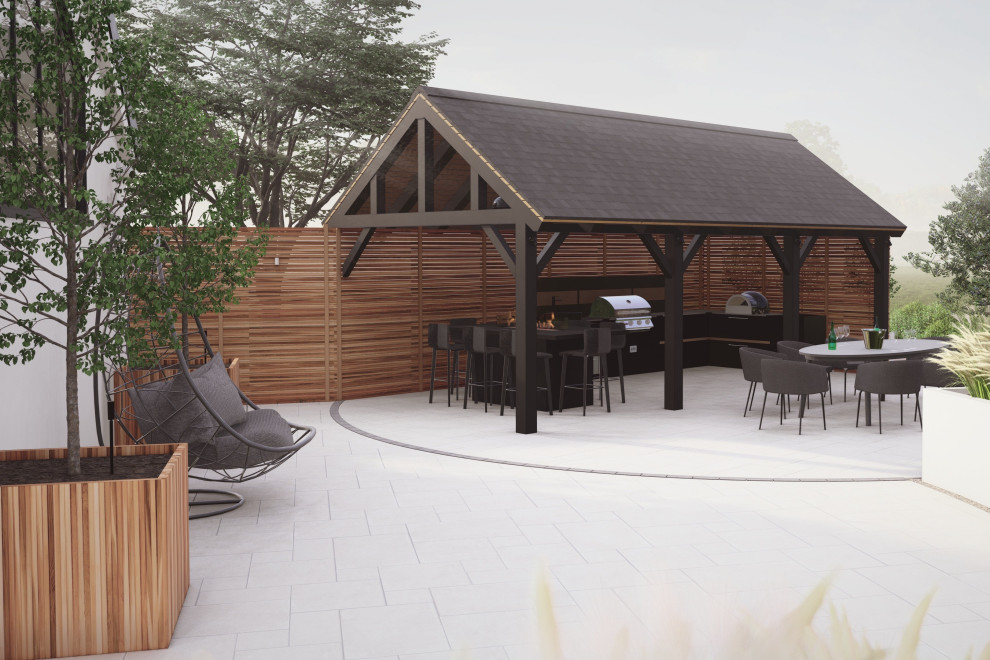 Exemple d'une terrasse arrière tendance de taille moyenne avec une cuisine d'été, du carrelage et une pergola.