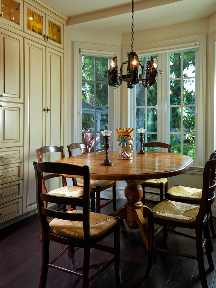 Inspiration for a mediterranean dining room in Miami with beige walls, dark hardwood floors and brown floor.