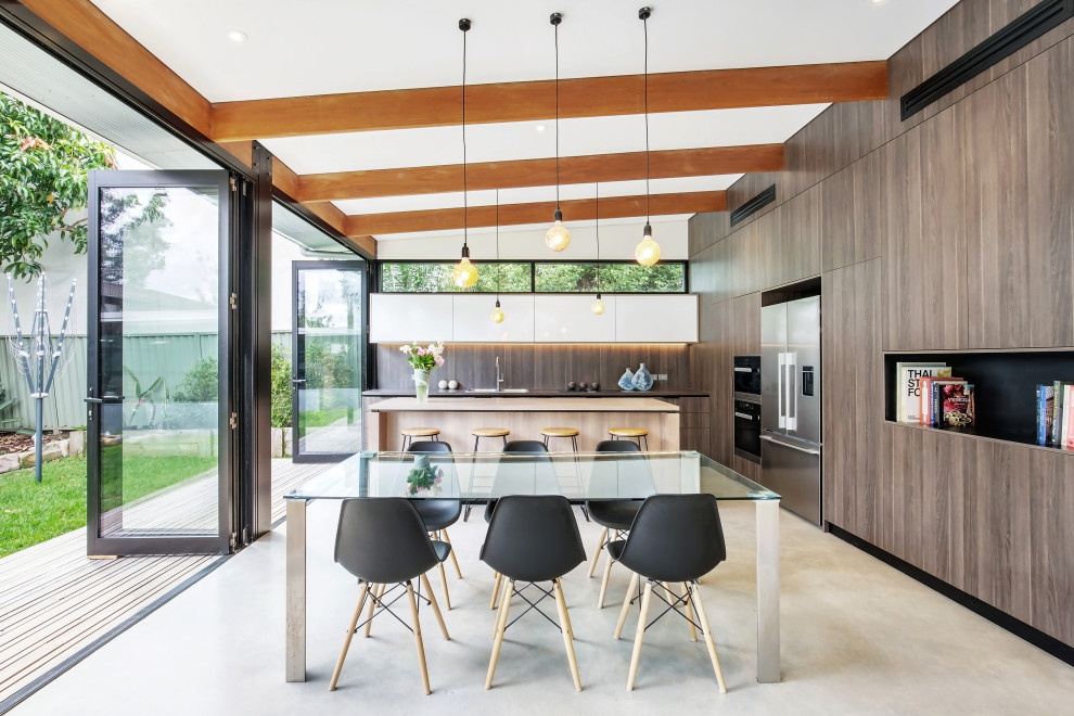 Idee per una sala da pranzo aperta verso la cucina minimal di medie dimensioni con pavimento in cemento, pavimento grigio e travi a vista