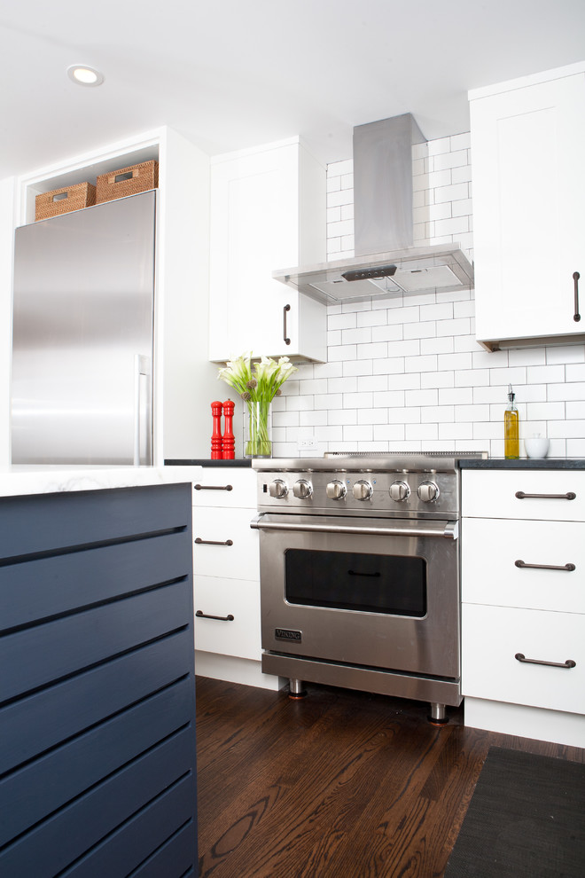 Photo of a modern l-shaped open plan kitchen in San Francisco with recessed-panel cabinets, white cabinets, white splashback, subway tile splashback and stainless steel appliances.