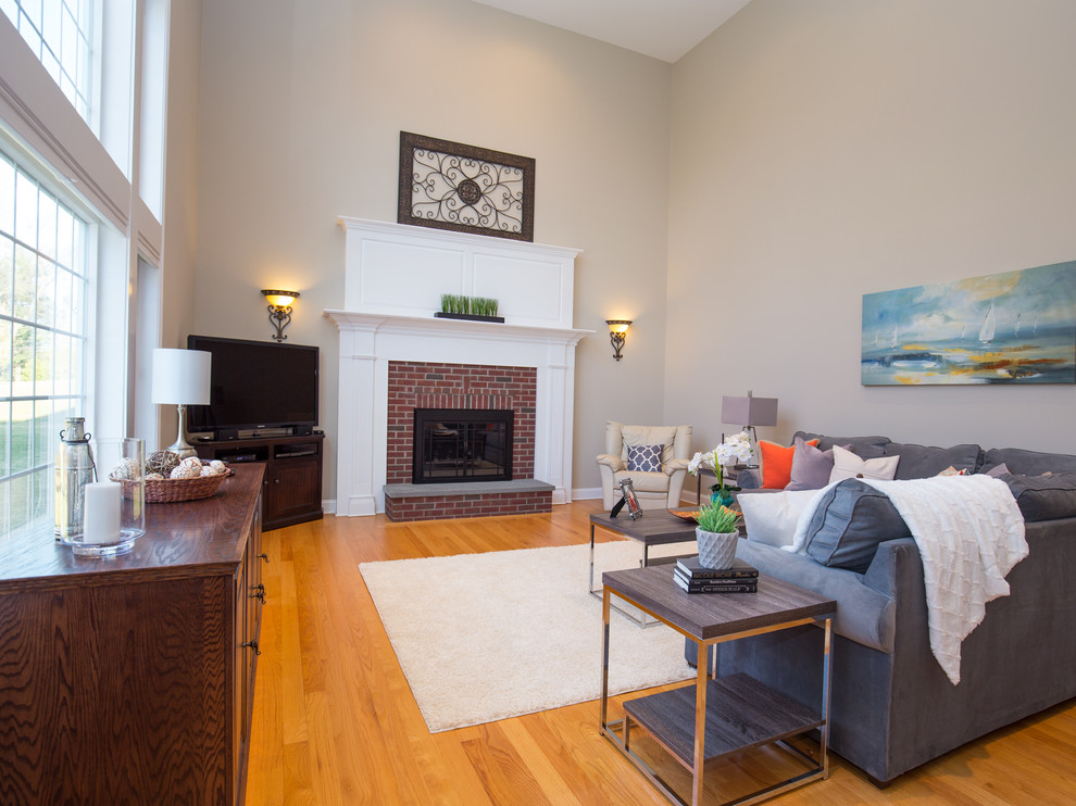 Mid-sized transitional open concept family room in Bridgeport with beige walls, medium hardwood floors, a standard fireplace, a brick fireplace surround and no tv.