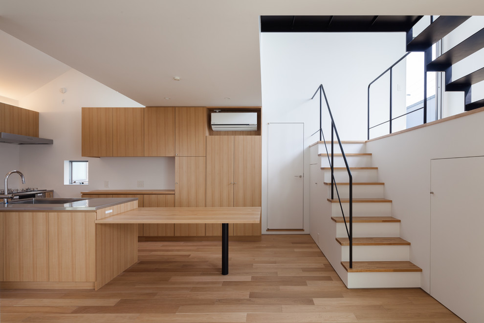 This is an example of a modern kitchen/dining combo in Tokyo with white walls, plywood floors, no fireplace and brown floor.