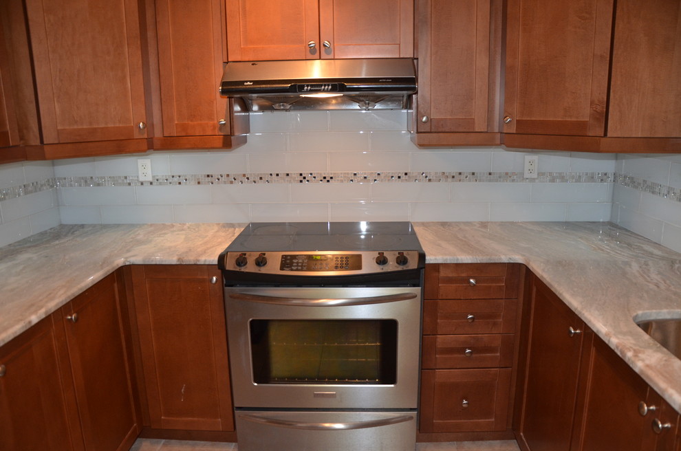 Inspiration for a small transitional u-shaped porcelain tile enclosed kitchen remodel in Toronto with a double-bowl sink, beaded inset cabinets, medium tone wood cabinets, granite countertops, white backsplash, glass tile backsplash, stainless steel appliances and no island