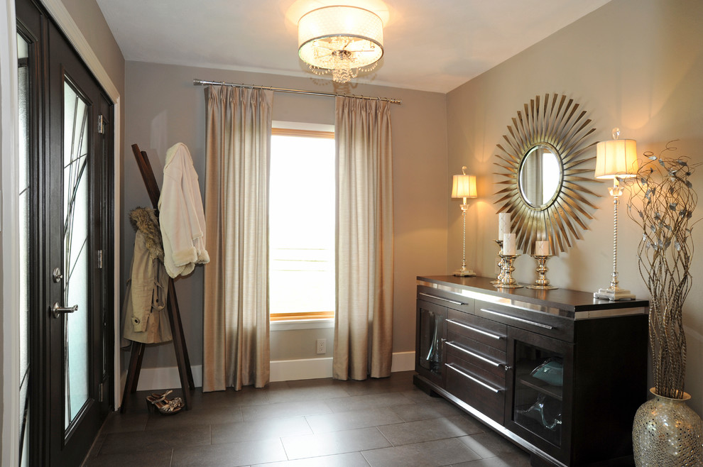 Example of a mid-sized transitional ceramic tile and brown floor foyer design in Cincinnati with beige walls and a dark wood front door