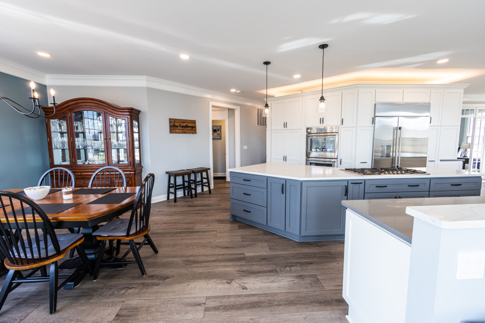 Inspiration for a large transitional vinyl floor and brown floor kitchen remodel in Baltimore with an undermount sink, shaker cabinets, white backsplash, porcelain backsplash, stainless steel appliances, an island and white countertops