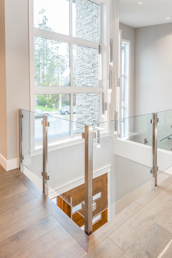 Photo of a mid-sized contemporary hallway in Vancouver with grey walls, medium hardwood floors and brown floor.
