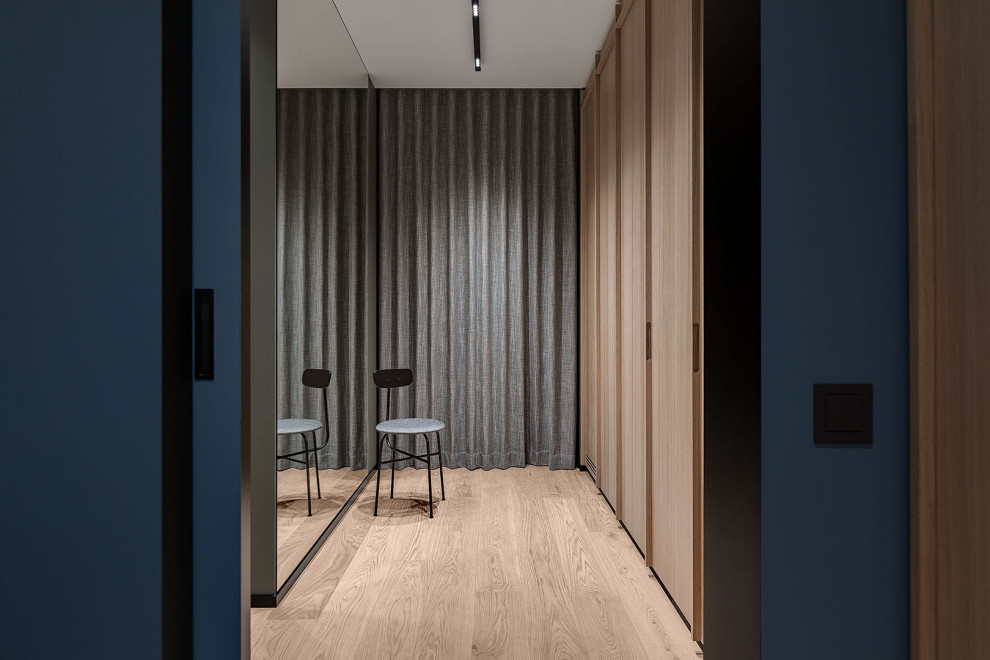 Design ideas for a medium sized scandinavian hallway in Other with green walls, medium hardwood flooring, a pivot front door, a medium wood front door, beige floors and panelled walls.