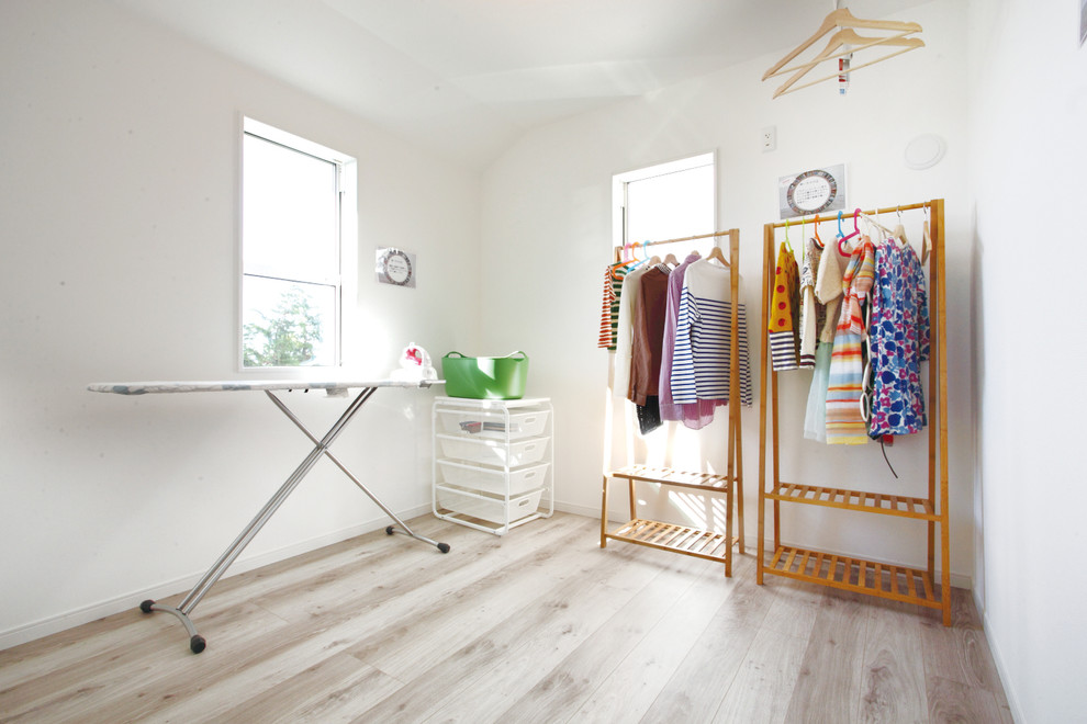 Idée de décoration pour un dressing room chalet neutre avec un sol en contreplaqué et un sol beige.