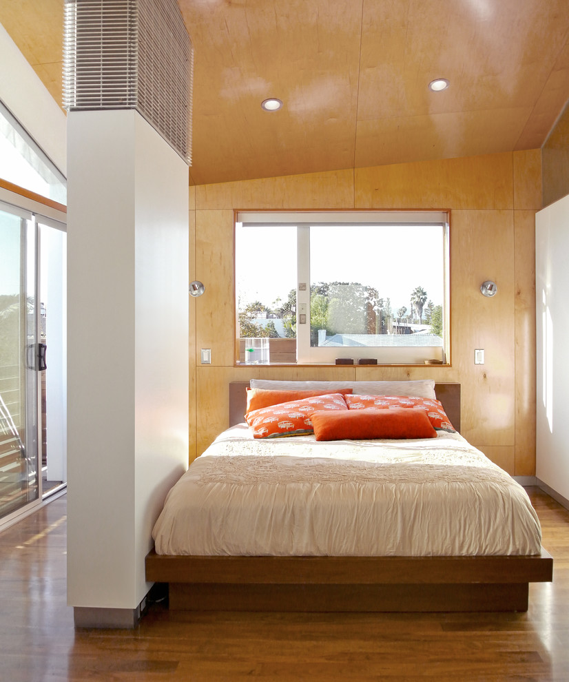 This is an example of a contemporary bedroom in Los Angeles with beige walls and medium hardwood floors.