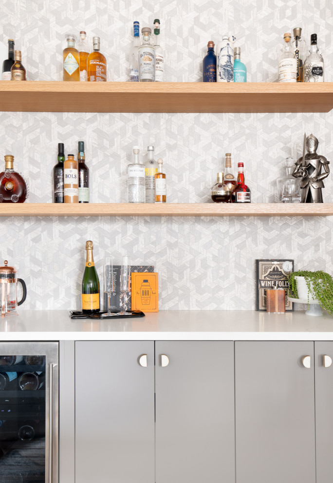 Design ideas for a mid-sized contemporary single-wall home bar in New York with flat-panel cabinets, grey cabinets, quartz benchtops and grey splashback.