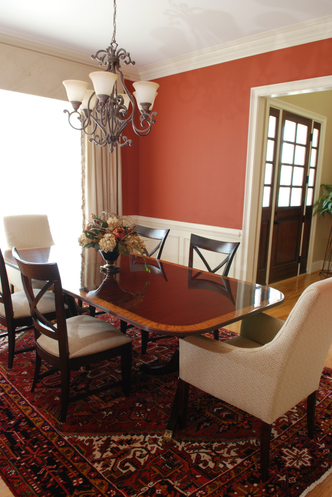 Mid-sized traditional separate dining room in Other with red walls and light hardwood floors.