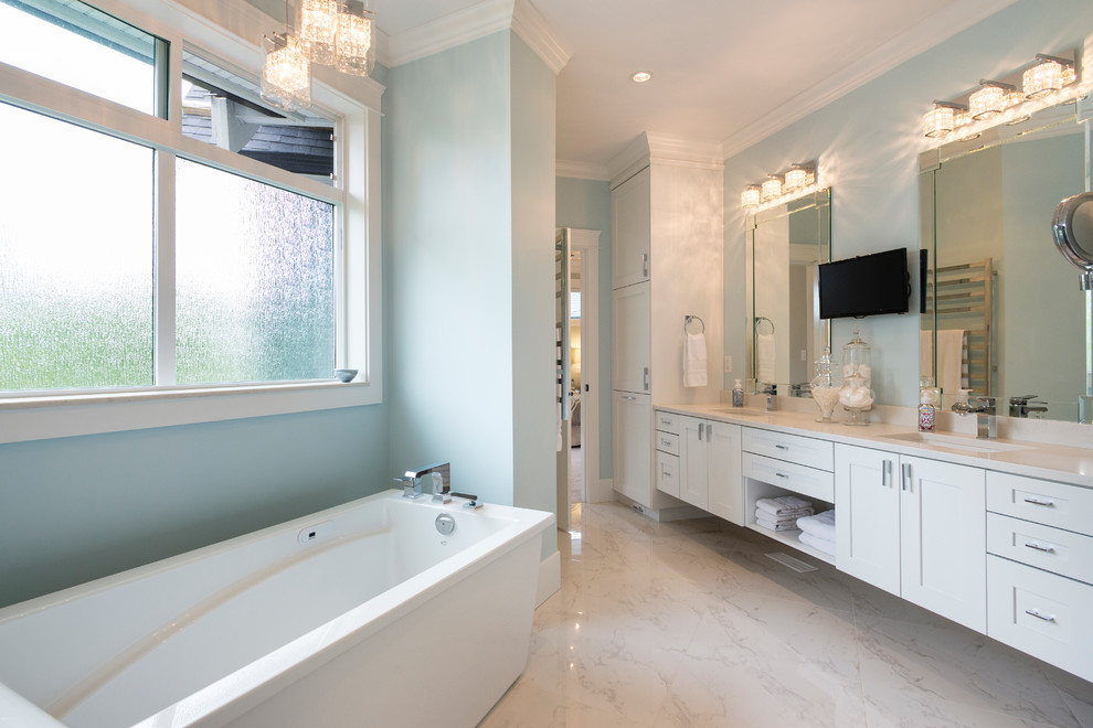 Large transitional bathroom in Vancouver with shaker cabinets, white cabinets, a freestanding tub, a corner shower, a two-piece toilet, white tile, stone tile, grey walls, marble floors, an undermount sink and engineered quartz benchtops.