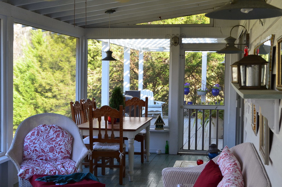 This is an example of a mid-sized traditional backyard screened-in verandah in Wilmington with decking and an awning.