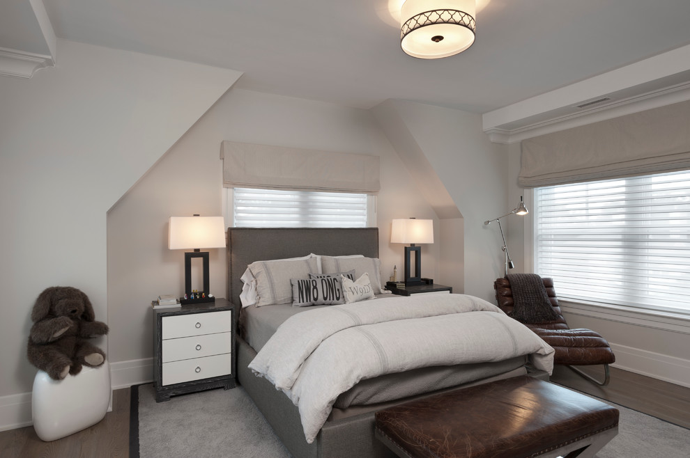 This is an example of a large transitional guest bedroom in New York with grey walls and dark hardwood floors.