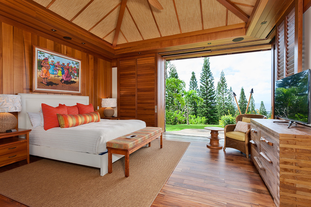 This is an example of a mid-sized tropical guest bedroom in Hawaii with brown floor, brown walls and medium hardwood floors.