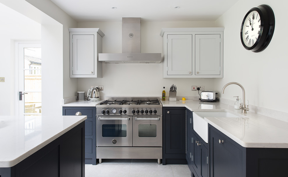Photo of a mid-sized traditional l-shaped eat-in kitchen in Gloucestershire with shaker cabinets, quartz benchtops, white splashback, ceramic floors, with island, a drop-in sink, grey cabinets and stainless steel appliances.