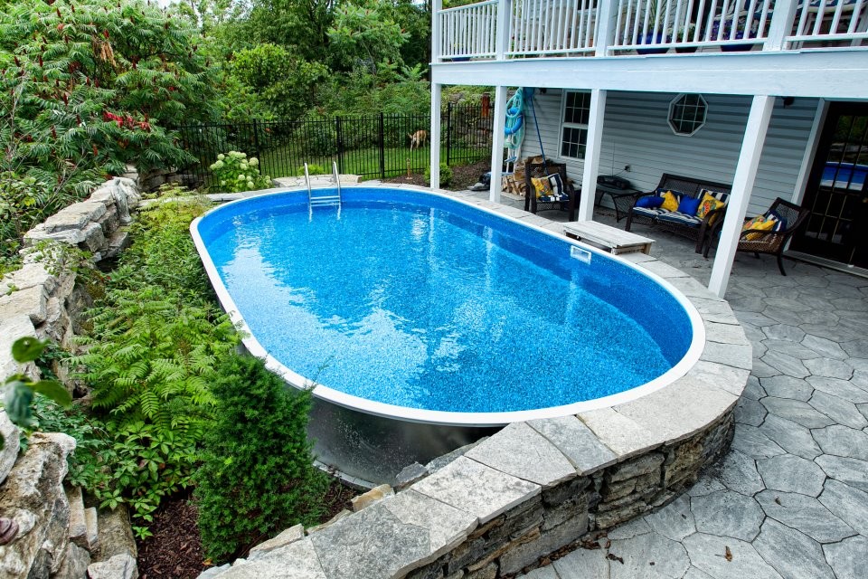 This is an example of a mid-sized modern backyard round aboveground pool in Ottawa with natural stone pavers.