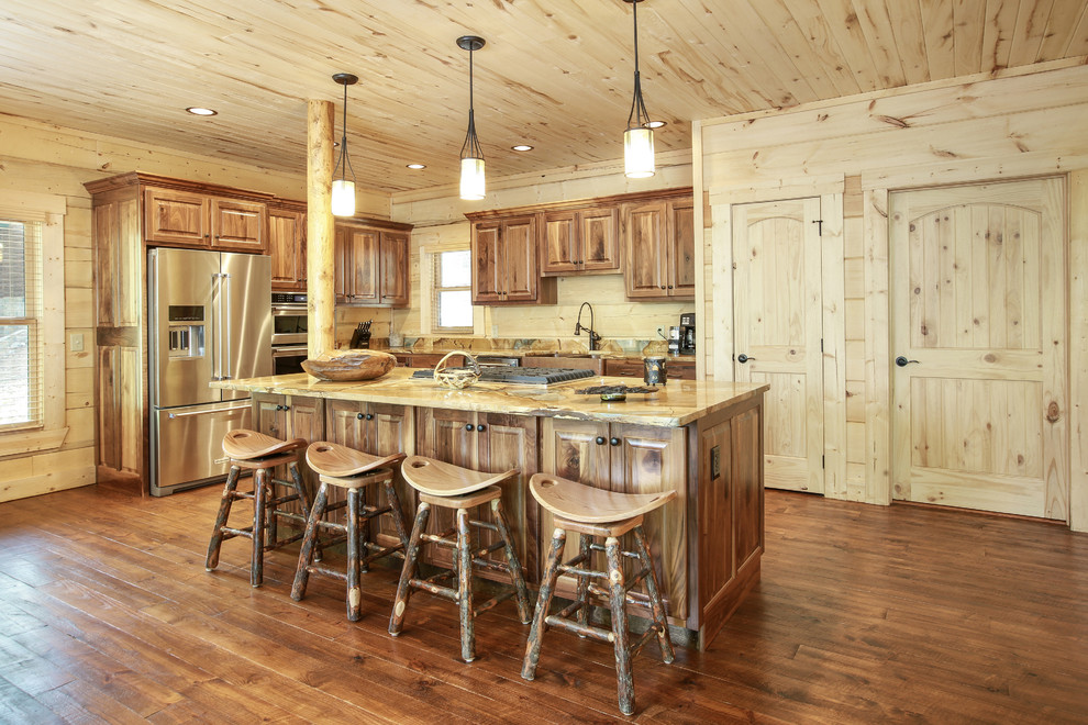 Country l-shaped kitchen in New Orleans with a farmhouse sink, raised-panel cabinets, medium wood cabinets, stainless steel appliances, dark hardwood floors, with island, brown floor and brown benchtop.
