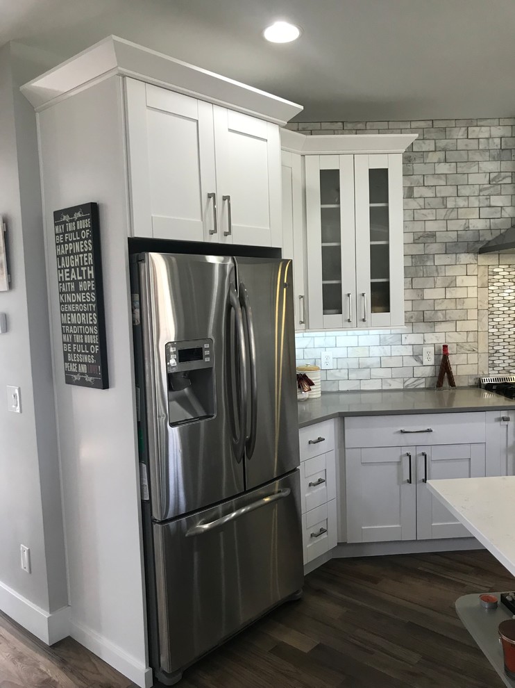 Eat-in kitchen - large transitional single-wall light wood floor and gray floor eat-in kitchen idea in Atlanta with a farmhouse sink, shaker cabinets, white cabinets, quartzite countertops, white backsplash, marble backsplash, stainless steel appliances, an island and white countertops