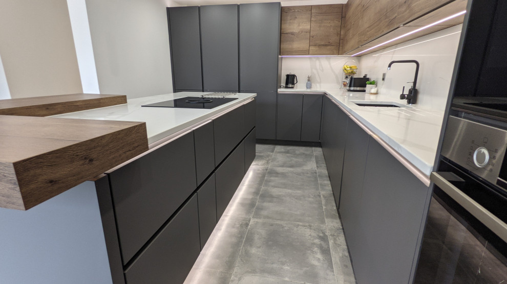 Photo of a medium sized contemporary cream and black enclosed kitchen in Other with a built-in sink, all styles of cabinet, black cabinets, quartz worktops, white splashback, black appliances, porcelain flooring, an island, grey floors, white worktops, all types of ceiling and feature lighting.