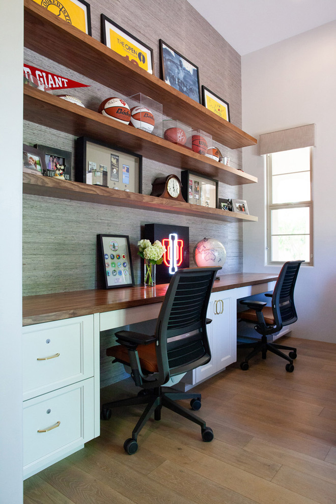 Photo of a transitional home office in Phoenix with grey walls, medium hardwood floors, a built-in desk and brown floor.
