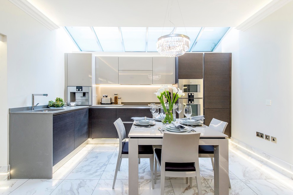 Mid-sized contemporary l-shaped eat-in kitchen in London with an undermount sink, flat-panel cabinets, dark wood cabinets, white splashback, panelled appliances, marble floors and no island.