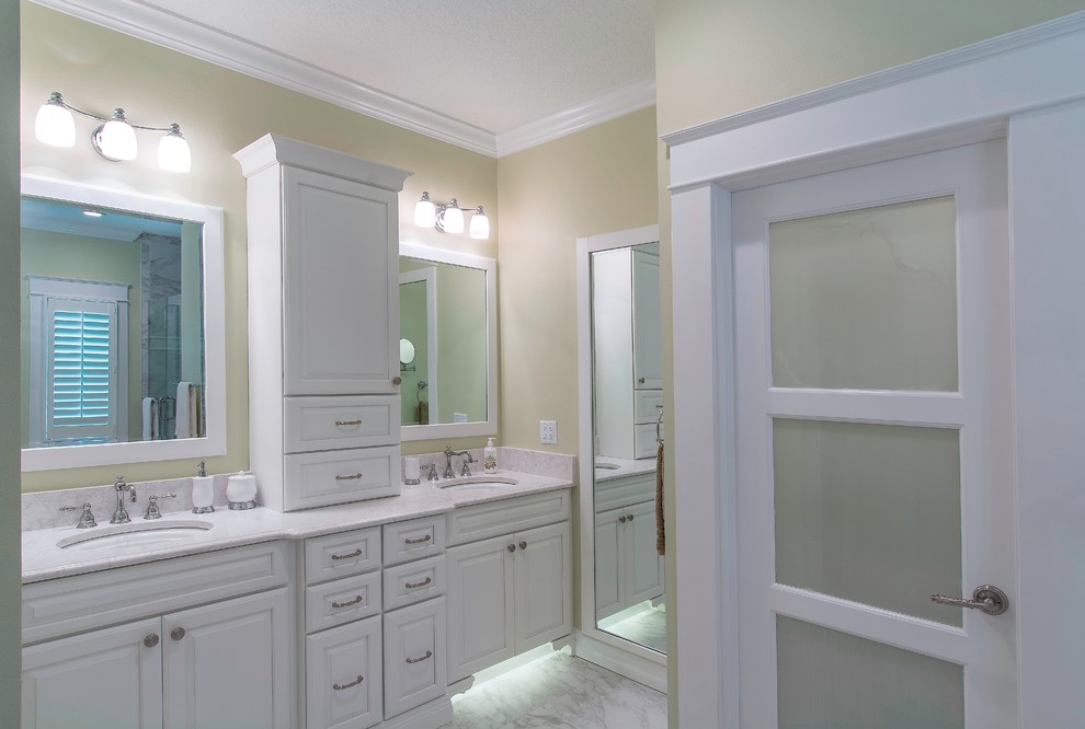 Photo of a traditional master bathroom in Tampa with an undermount sink, raised-panel cabinets, white cabinets, engineered quartz benchtops, a freestanding tub, a corner shower, a wall-mount toilet, gray tile, porcelain tile, green walls and porcelain floors.