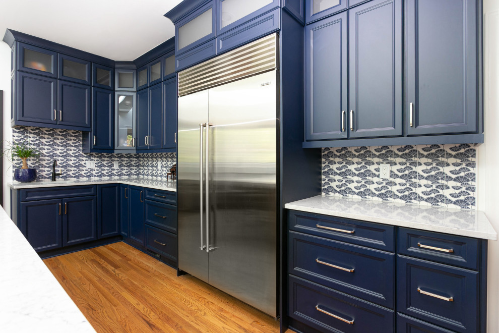 Foto di un cucina con isola centrale stile marino con ante blu, top in quarzo composito, paraspruzzi con piastrelle in ceramica e top bianco