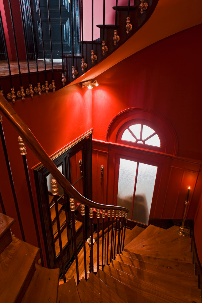 Réalisation d'un grand escalier courbe tradition avec des marches en bois et des contremarches en bois.